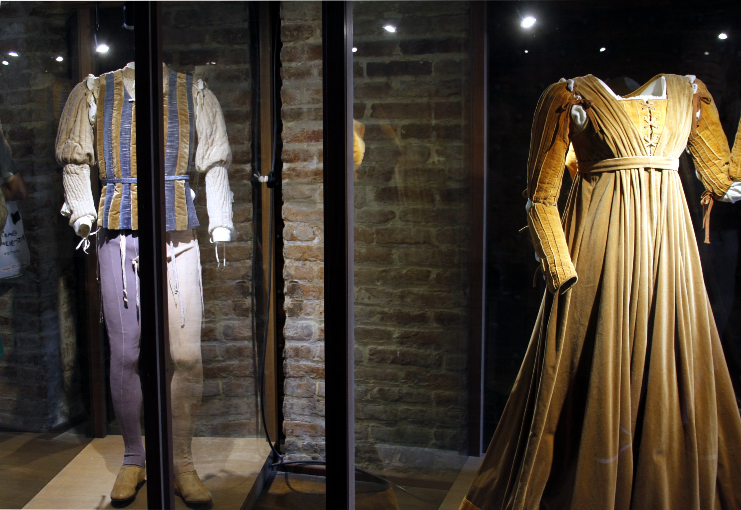 Romeo and Juliet costumes displayed in glass cases at the house-museum